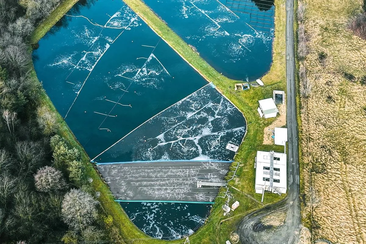 Operating wastewater lagoon cells with surface aeration, separated by grass berms